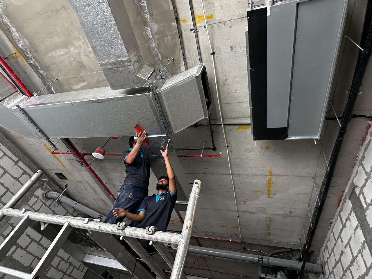 Rapid Home team positioning ductwork inside a commercial unit