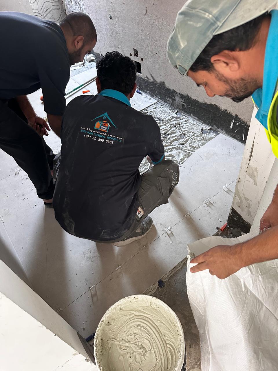 Rapid Home team installing bathroom floor tiles
