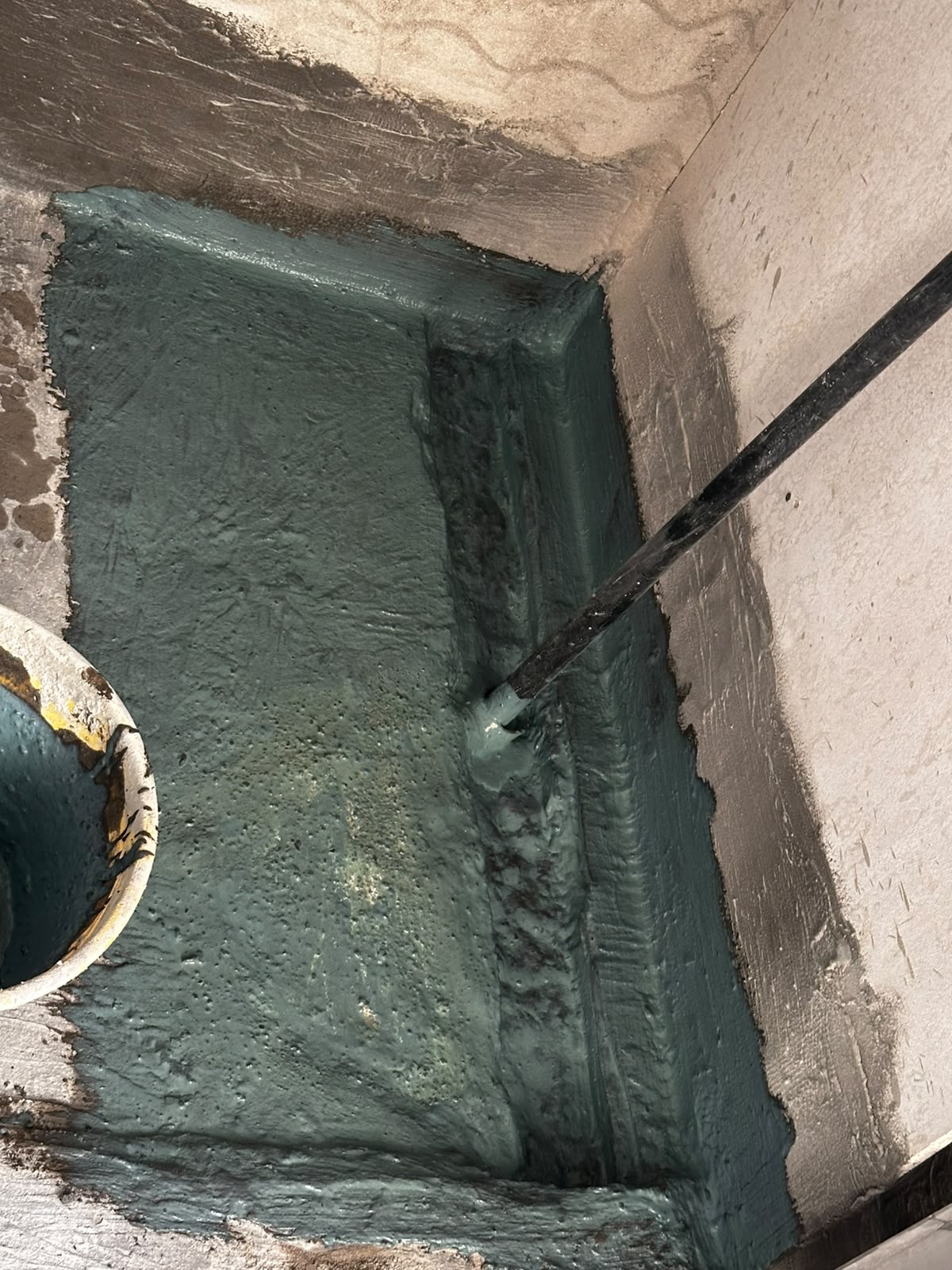 Waterproofing coating applied before bathroom finishes